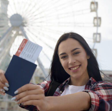 portrait-smiling-woman-showing-air-ticket-passport