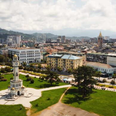 Aerial drone view of Batumi, Georgia. Old and modern buildings, greenery, roads, mountains, cloudy sky